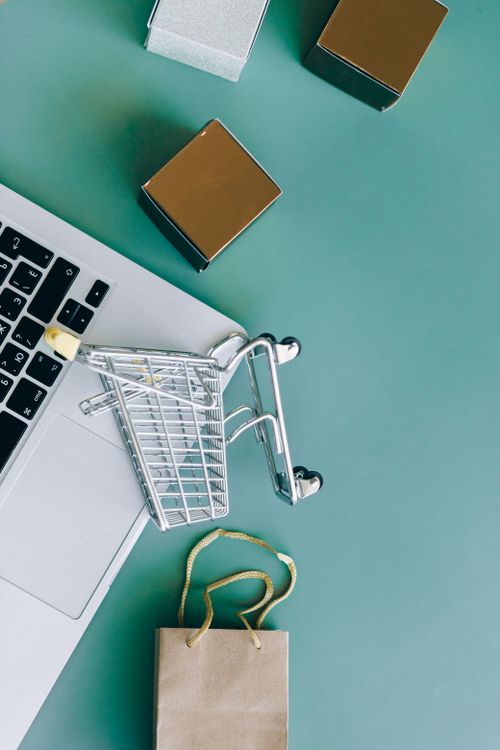 Laptop and shopping cart arranged for an ecommerce workspace